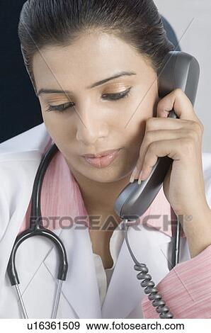 Close-up of a female doctor talking on the telephone View Large Photo Image Stock Photo - Close-up of a female doctor talking on the telephone. Fotosearch