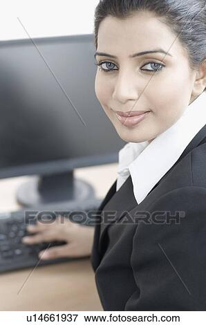 Stock Photo - Portrait of a businesswoman working on a computer. Fotosearch