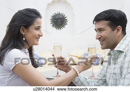 Mid adult couple feeding champagne to each other View Large Photo Image Picture - Mid adult couple feeding champagne to each other. Fotosearch