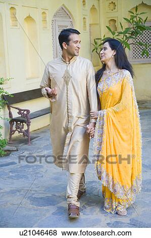 Mid adult couple holding hands of each other and walking View Large Photo Image Stock Photo - Mid adult couple holding hands of each other and walking. Fotosearch