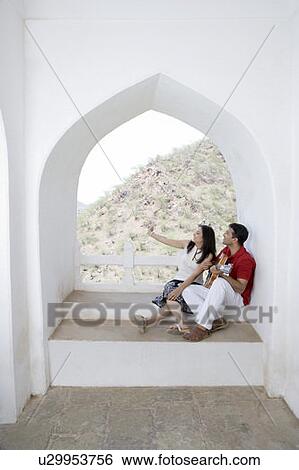 Mid adult couple sitting at the balcony of a palace, Neemrana Fort Palace, Neemrana, Alwar, Rajasthan, India View Large Photo Image Stock Photograph - Mid adult couple sitting at the balcony of a palace, Neemrana Fort Palace, Neemrana, Alwar, Rajasthan, India. Fotosearch