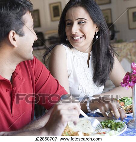 Mid adult couple sitting in a restaurant and smiling View Large Photo Image Stock Photo - Mid adult couple sitting in a restaurant and smiling. Fotosearch