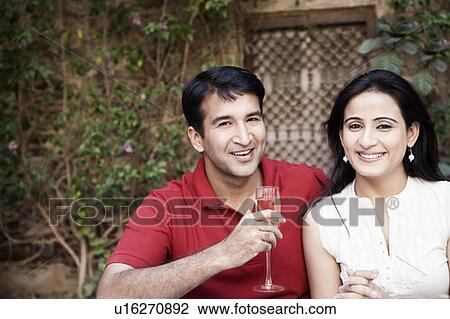 Portrait of a mid adult man sitting with a mid adult woman and holding a champagne flute View Large Photo Image Stock Image - Portrait of a mid adult man sitting with a mid adult woman and holding a champagne flute. Fotosearch