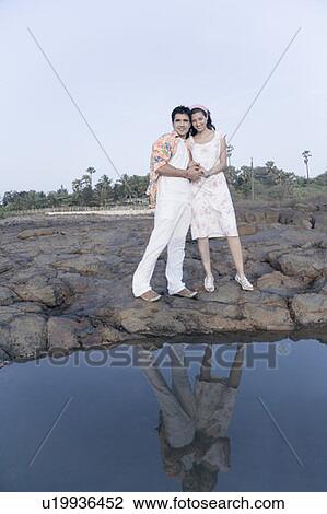 Portrait of a young couple standing on rocks View Large Photo Image Stock Image - Portrait of a young couple standing on rocks. Fotosearch
