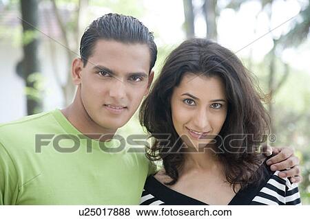 Portrait of a young man with his arm around a young woman View Large Photo Image Stock Photo - Portrait of a young man with his arm around a young woman. Fotosearch