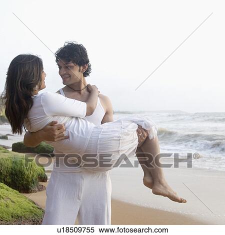 Young man carrying a young woman on the beach, Goa, India View Large Photo Image Stock Photography - Young man carrying a young woman on the beach, Goa, India. Fotosearch