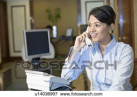 Close-up of a businesswoman talking on the telephone and smiling View Large Photo Image Stock Photo - Close-up of a businesswoman talking on the telephone and smiling. Fotosearch