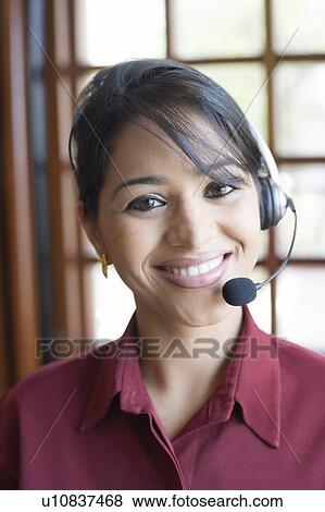 Portrait of a businesswoman wearing a headset and smiling View Large Photo Image Stock Photo - Portrait of a businesswoman wearing a headset and smiling. Fotosearch