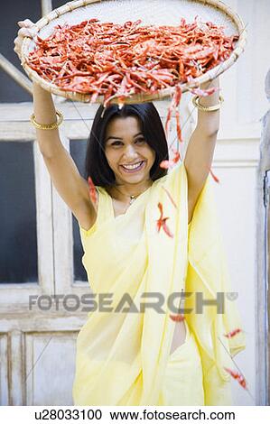 Portrait of a young woman spraying red chili peppers from a tray View Large Photo Image Stock Image - Portrait of a young woman spraying red chili peppers from a tray. Fotosearch