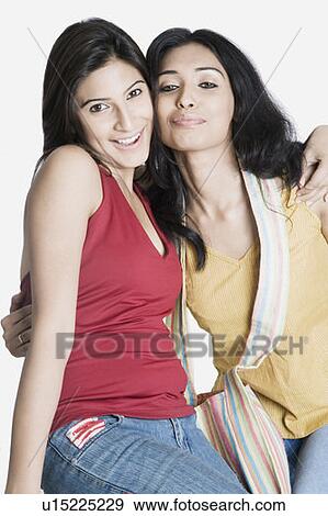 Portrait of two young women with their arms around each other and smiling View Large Photo Image Stock Photo - Portrait of two young women with their arms around each other and smiling. Fotosearch