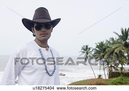 Picture - Close-up of a young man wearing a cowboy hat. Fotosearch
