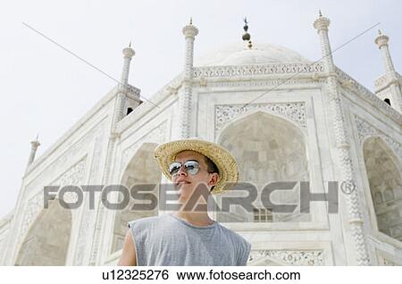 Low angle view of a young man in front of a mausoleum, Taj Mahal, Agra, Uttar Pradesh, India View Large Photo Image Stock Photograph - Low angle view of a young man in front of a mausoleum, Taj Mahal, Agra, Uttar Pradesh, India. Fotosearch