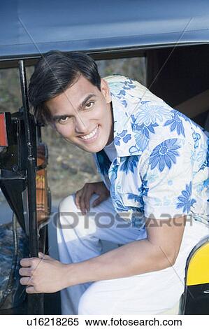 Portrait of a young man sitting in an auto rickshaw View Large Photo Image Stock Photography - Portrait of a young man sitting in an auto rickshaw. Fotosearch