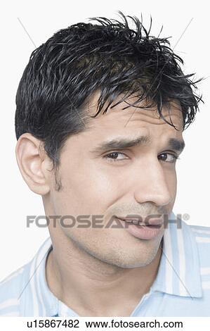 Stock Image - Portrait of a young man smirking. Fotosearch