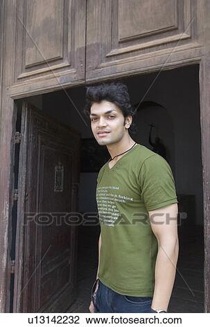 Portrait of a young man standing at a doorway, Goa, India View Large Photo Image Stock Image - Portrait of a young man standing at a doorway, Goa, India. Fotosearch