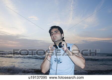 Stock Photography - Portrait of a young man with headphones around his neck. Fotosearch