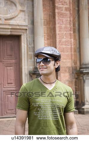Young man smiling in front of a building, Goa, India View Large Photo Image Stock Image - Young man smiling in front of a building, Goa, India. Fotosearch