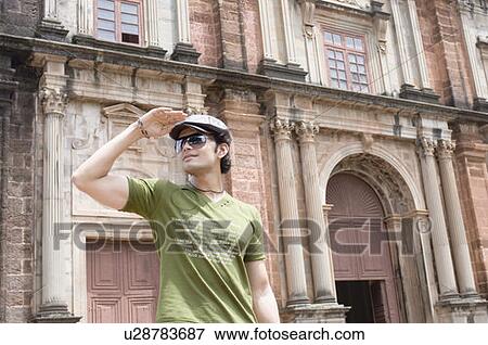 Young man standing in front of a building, Goa, India View Large Photo Image Stock Photo - Young man standing in front of a building, Goa, India. Fotosearch