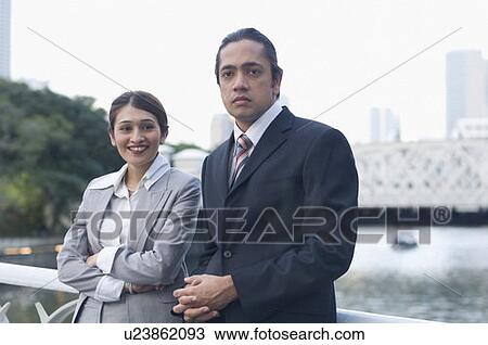 Businesswoman standing with a businessman and smiling View Large Photo Image Stock Image - Businesswoman standing with a businessman and smiling. Fotosearch