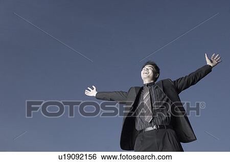 Low angle view of a businessman with his arms outstretched and laughing View Large Photo Image Stock Photograph - Low angle view of a businessman with his arms outstretched and laughing. Fotosearch