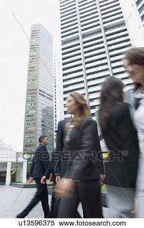 Low angle view of business executives walking on the road with skyscrapers in the background, Singapore View Large Photo Image Stock Photography - Low angle view of business executives walking on the road with skyscrapers in the background, Singapore. Fotosearch