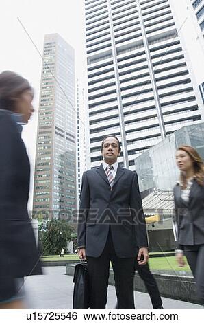 Portrait of a businessman standing with skyscrapers in the background, Singapore View Large Photo Image Stock Photograph - Portrait of a businessman standing with skyscrapers in the background, Singapore. Fotosearch