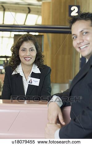 Portrait of a businessman with an airline check-in attendant at an airport check-in counter View Large Photo Image Stock Photography - Portrait of a businessman with an airline check-in attendant at an airport check-in counter. Fotosearch