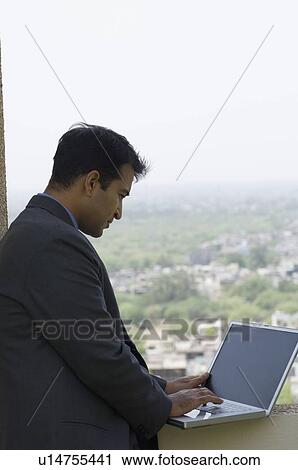 Side profile of a businessman using a laptop View Large Photo Image Stock Image - Side profile of a businessman using a laptop. Fotosearch