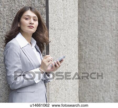 Side profile of a businesswoman using a palmtop, Singapore View Large Photo Image Stock Image - Side profile of a businesswoman using a palmtop, Singapore. Fotosearch