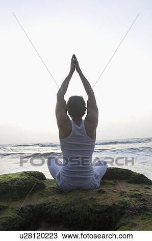 Rear view of a young man doing yoga on the beach, Goa, India View Large Photo Image Stock Image - Rear view of a young man doing yoga on the beach, Goa, India. Fotosearch