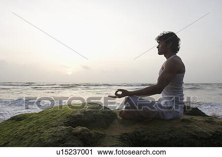 Side profile of a young man meditating in lotus position on the beach, Goa, India View Large Photo Image Stock Image - Side profile of a young man meditating in lotus position on the beach, Goa, India. Fotosearch