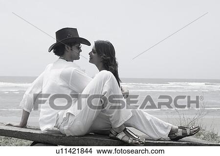 Young couple sitting on the beach View Large Photo Image Picture - Young couple sitting on the beach. Fotosearch