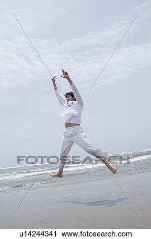 Young man exercising on the beach View Large Photo Image Stock Image - Young man exercising on the beach. Fotosearch