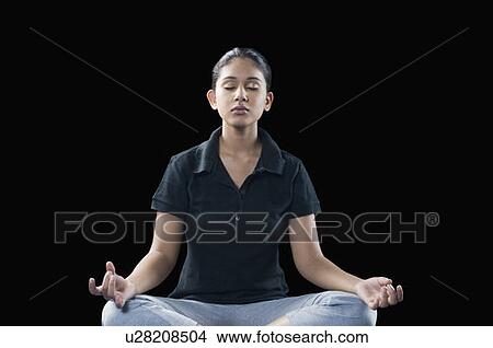 Young woman meditating in a lotus position View Large Photo Image Picture - Young woman meditating in a lotus position. Fotosearch