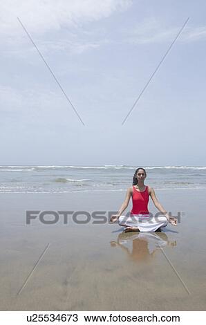 Young woman meditating on the beach View Large Photo Image Stock Image - Young woman meditating on the beach. Fotosearch