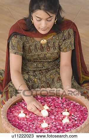 Close-up of a young woman putting oil lamp in a bowl full with rose petals View Large Photo Image Stock Image - Close-up of a young woman putting oil lamp in a bowl full with rose petals. Fotosearch