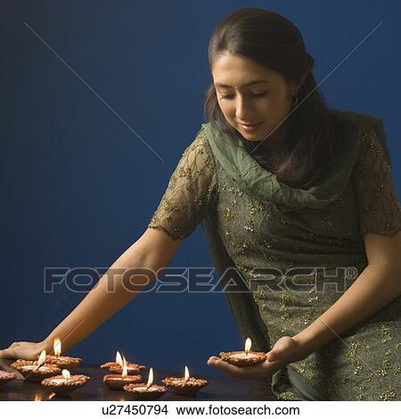 Young woman lighting oil lamps View Large Photo Image Picture - Young woman lighting oil lamps. Fotosearch