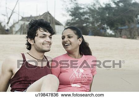 Close-up of a young couple leaning on the beach and smiling View Large Photo Image Stock Photograph - Close-up of a young couple leaning on the beach and smiling. Fotosearch