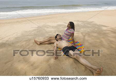 High angle view of a young couple relaxing on the beach View Large Photo Image Stock Image - High angle view of a young couple relaxing on the beach. Fotosearch