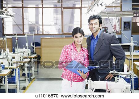 Portrait of a businessman standing with a female fashion designer in a textile industry View Large Photo Image Stock Image - Portrait of a businessman standing with a female fashion designer in a textile industry. Fotosearch
