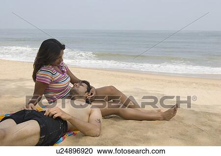Stock Image - Young couple relaxing on the beach. Fotosearch