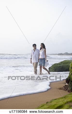 Young couple walking together on the beach View Large Photo Image Picture - Young couple walking together on the beach. Fotosearch