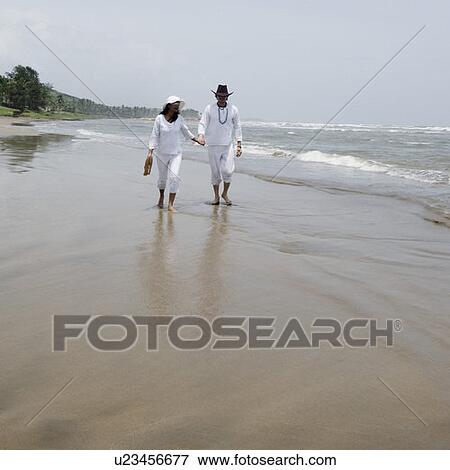 Young couple walking with holding hands on the beach View Large Photo Image Stock Photo - Young couple walking with holding hands on the beach. Fotosearch