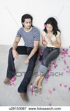 Stock Photo - High angle view of a young couple sitting on the floor. Fotosearch