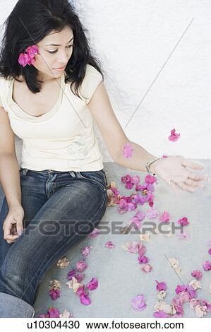 High angle view of a young woman leaning against a wall with petals around her View Large Photo Image Stock Image - High angle view of a young woman leaning against a wall with petals around her. Fotosearch
