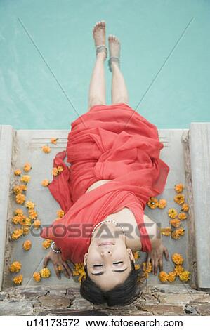 High angle view of a young woman sitting on the steps of a swimming pool View Large Photo Image Stock Image - High angle view of a young woman sitting on the steps of a swimming pool. Fotosearch