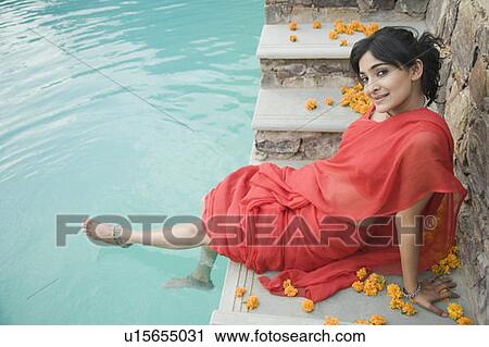 Portrait of a young woman sitting at the poolside View Large Photo Image Stock Image - Portrait of a young woman sitting at the poolside. Fotosearch
