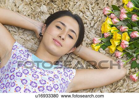 Portrait of a young woman with her hands behind her head View Large Photo Image Stock Image - Portrait of a young woman with her hands behind her head. Fotosearch