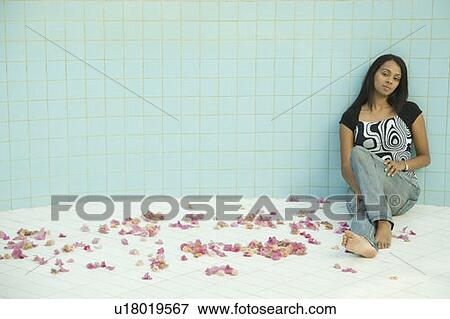 Stock Photo - Young woman sitting in an empty swimming pool. Fotosearch