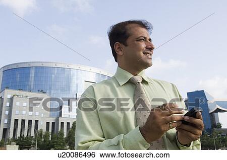Businessman using a mobile phone with a stylus View Large Photo Image Stock Photograph - Businessman using a mobile phone with a stylus. Fotosearch